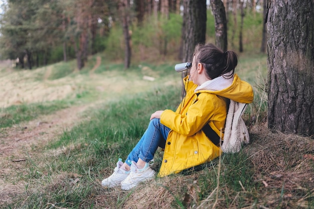 Kleine ontdekkingsreiziger met verrekijker speelt in het bos zoek en onderzoek reis- en avontuurconcept kinderclub kamperen