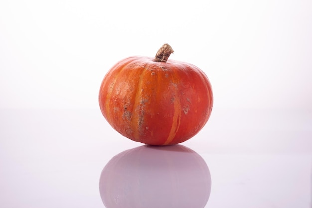 Kleine oranje pompoen geïsoleerd op een witte achtergrond