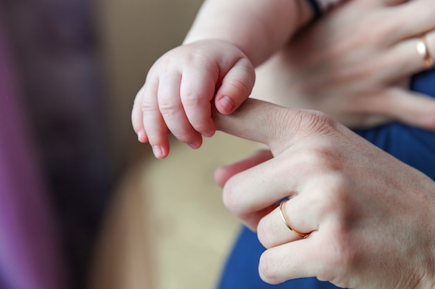 Kleine pasgeboren baby mannelijke of vrouwelijke baby hand met moeder vinger