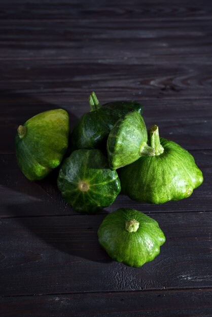 Kleine patty pan patisson squash op donkere houten achtergrond met kopie ruimte