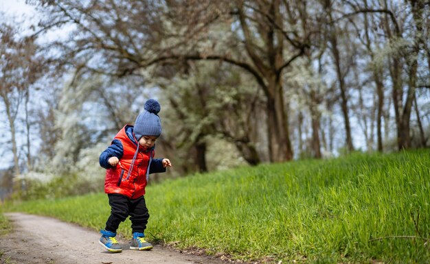 Kleine peuter jongen en zijn moeder lopen in het park op een lente dag