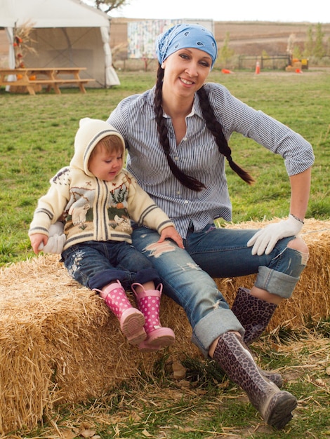 Kleine peuter met haar moeder op de boerderij.