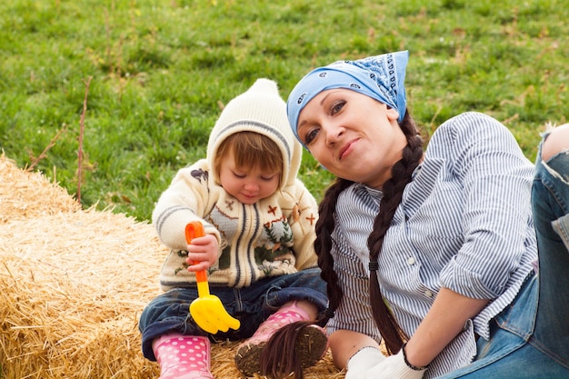 Kleine peuter met haar moeder op de boerderij.