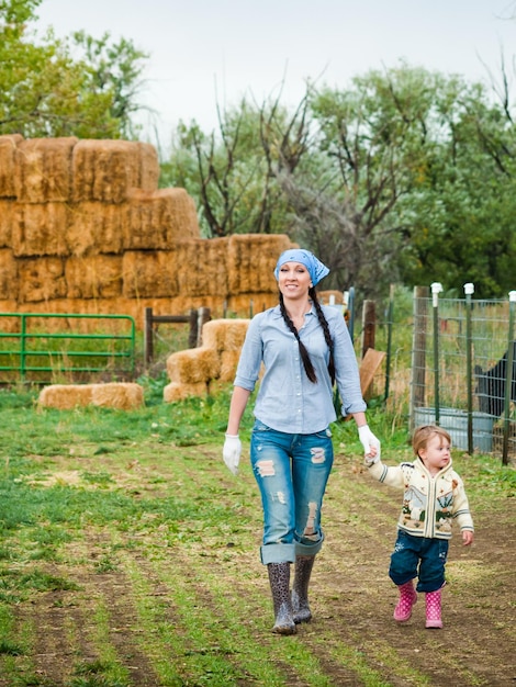 Kleine peuter met haar moeder op de boerderij.