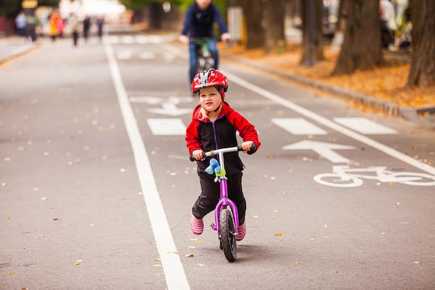 Kleine peuterjongen die heel snel op het speciale fietspad rijdt op het speciale fietspad Actiefoto van een kleine onverschrokken sportieve jongen buiten in de stad