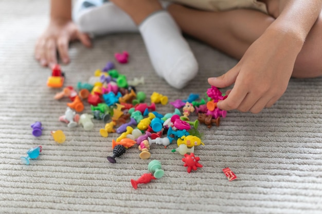 Kleine peuterjongen spelen met kleurrijk plastic speelgoed thuis creatieve spelverbeelding