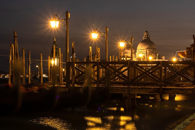 Kleine pier in Venetië 's nachts en de basiliek van Santa Maria della Salud op de achtergrond