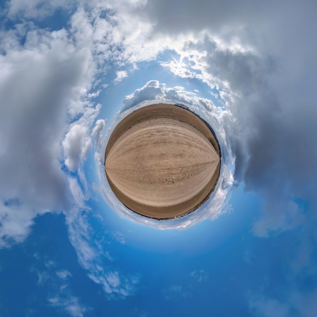 Kleine planeet in blauwe bewolkte hemel met prachtige wolken met transformatie van bolvormig panorama 360 graden bolvormige abstracte luchtfoto Kromming van de ruimte