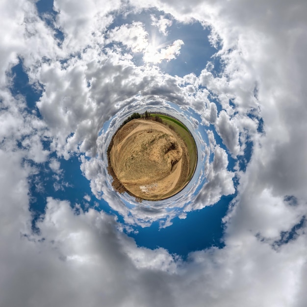 Kleine planeet in blauwe lucht met prachtige wolken met transformatie van bolvormig panorama 360 graden bolvormige abstracte luchtfoto kromming van de ruimte