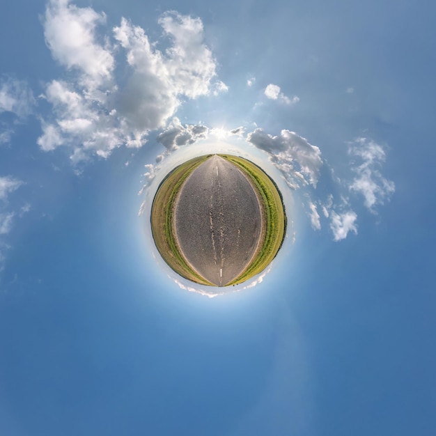 Kleine planeet in blauwe lucht met zon en prachtige wolken Transformatie van bolvormig panorama 360 graden Bolvormige abstracte luchtfoto Kromming van de ruimte