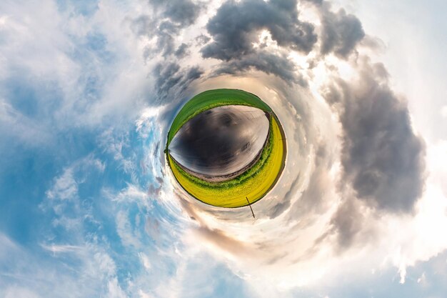 Kleine planeet transformatie van bolvormig panorama 360 graden bolvormige abstracte luchtfoto in veld in mooie avond met geweldige mooie wolken Kromming van de ruimte