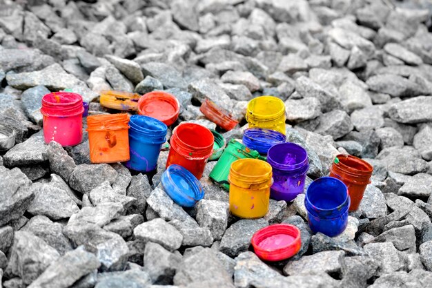 Kleine potjes van onderverf van verschillende kleuren op grijze kiezelstenen