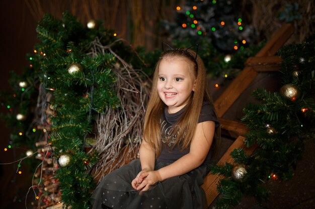 Kleine prinses poseren met make-up in kerstversiering.