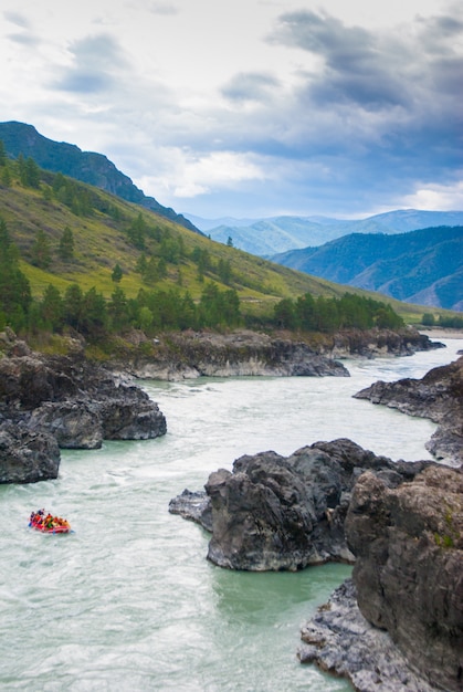 Kleine rafting boot in snelle bergrivier tussen rotsen