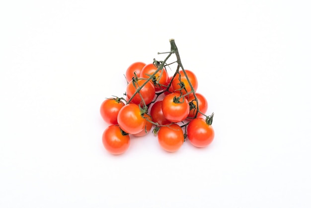 Kleine rode cherry biologische tomaten op witte achtergrond Gezond eten concept Veganistisch eten Minimale kaart met kopieerruimte