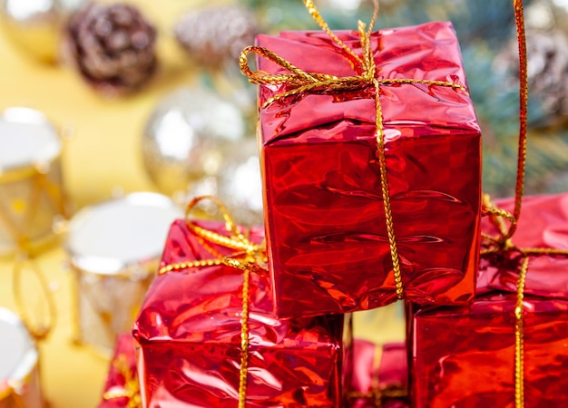 Foto kleine rode dozen met geschenken in een stapel op tafel nieuwjaarsdecorelementen close-up