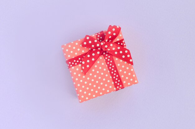 Foto kleine rode geschenkdoos met lint ligt op violet