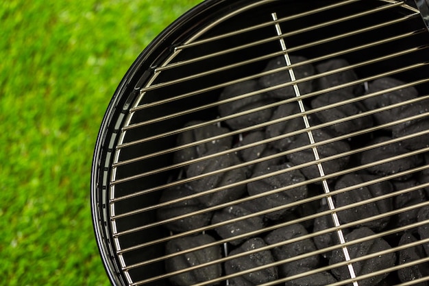 Kleine ronde houtskoolgrill klaar om te grillen op de zomerpicknick.