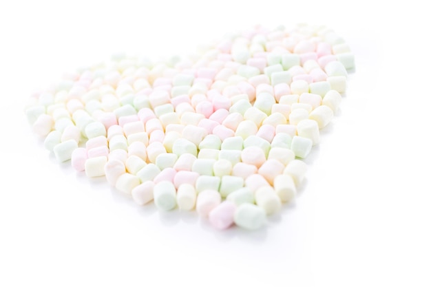 Kleine ronde veelkleurige marshmallows op een witte pagina's.