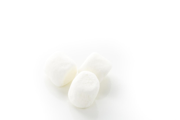 Kleine ronde witte marshmallows op een witte backgrouns.