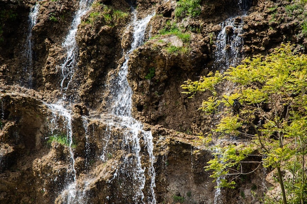 Kleine rotsachtige waterval die in een meer stroomt