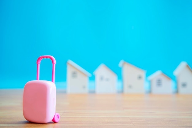 Kleine roze koffer met klein houten huisje vakantiehuizen