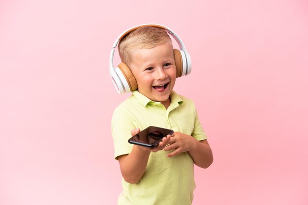 Kleine Russische jongen die naar muziek luistert met een koptelefoon over geïsoleerde achtergrond