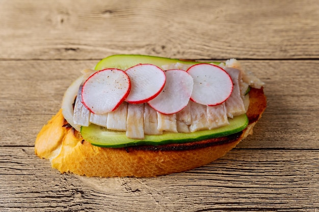 Kleine sandwiches met groenten vis komkommer ui radijs sandwich haring houten achtergrond top v
