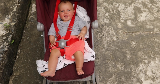 kleine schattige en nieuwsgierige baby in kinderwagen buitenshuis