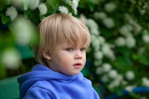 Foto kleine schattige jongen onder bloeiende tak het concept van allergieën verdriet eenzaamheid