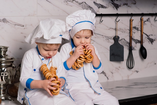 Kleine schattige kok met bestek zittend op een keuken