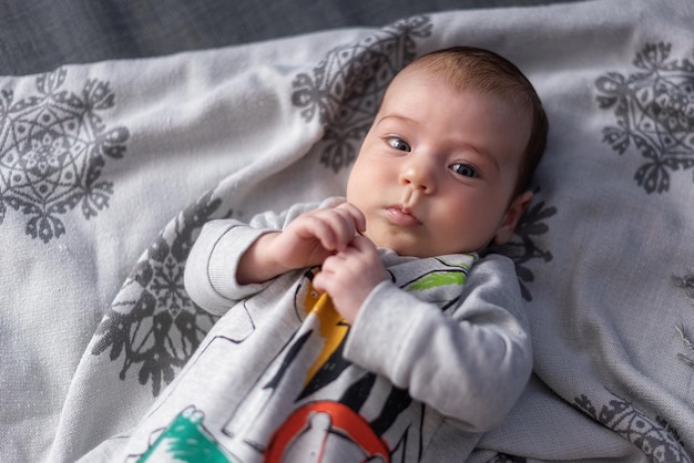 kleine schattige serieuze baby kijkt zorgvuldig in het frame