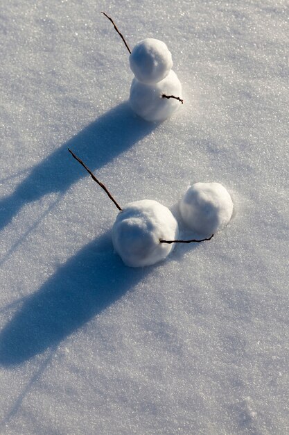 Kleine sneeuwmannen staan op de sneeuw in het winterseizoen, sneeuwmannen gemaakt van sneeuw in de winter