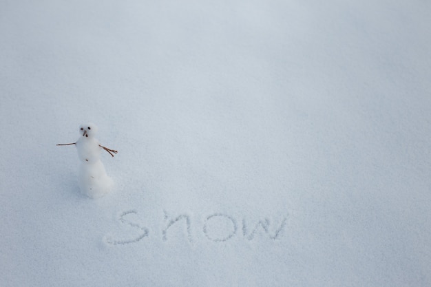 Kleine sneeuwpop in sneeuw Copy Space tekst winter