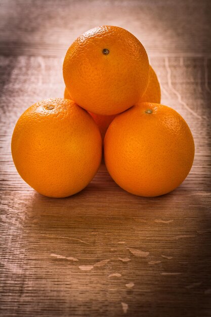 Kleine stapel oranje vruchten op houten bureau