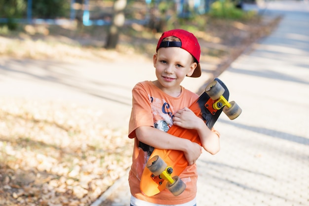 Kleine stedelijke jongen met een centskateboard