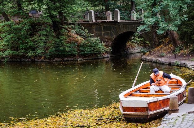 Foto kleine stenen brug over de rivier en een boot in het park. oekraïne