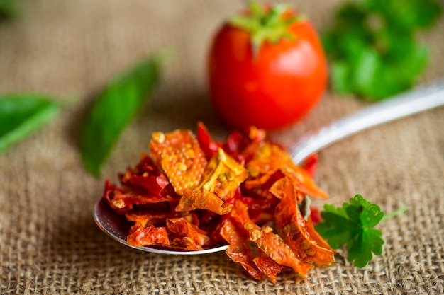 Kleine stukjes gedroogde tomaten naast verse tomaten