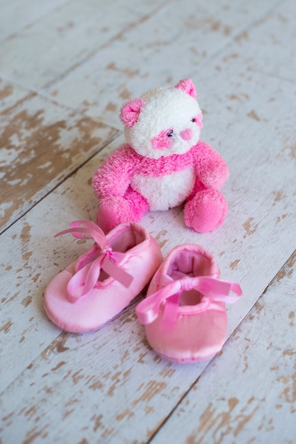 Kleine teddybeer en kinderschoenen op een houten ondergrond wooden