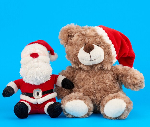 Kleine teddybeer in rode kerstmuts en kerstman