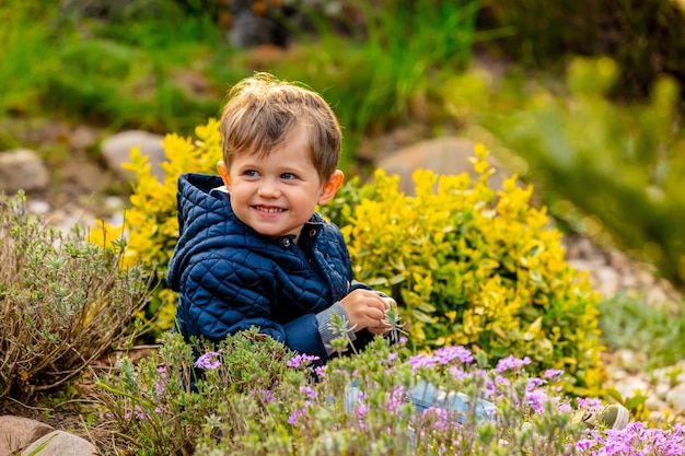 Kleine todler spelen met bloemen in de tuin