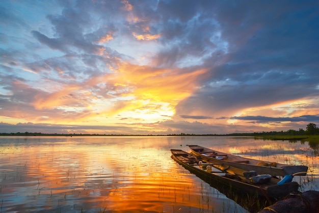 Kleine traditionele Thaise vissersboten afgemeerd rustig aan de rivier bij zonsondergang.