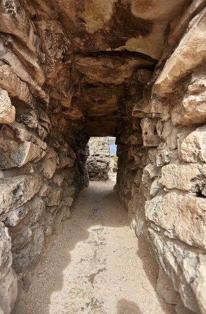 Kleine tunnel met stenen bakstenen muren creëert doorgangen tussen de muren van de ruïnes van Tulum in Mexico