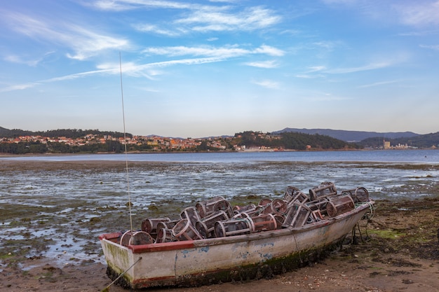 Kleine verlaten boot vol met visgereedschap op een Combarro strand in Galicië