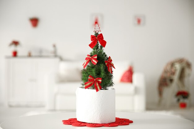 Kleine versierde kerstboom op de tafel in de kamer, close-up