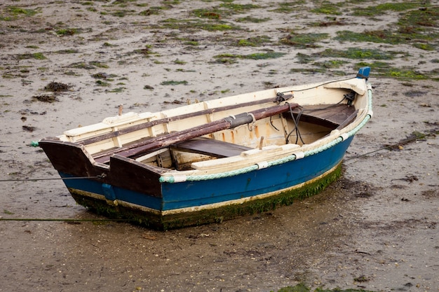 Kleine vissersboot gestrand op het natte zand