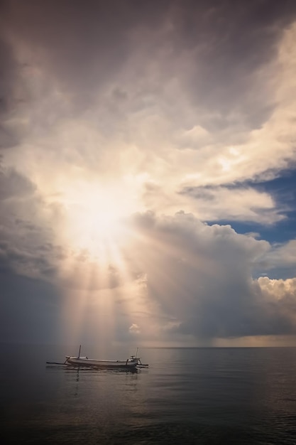 Kleine vissersboot op de kalme zee bij zonsondergang