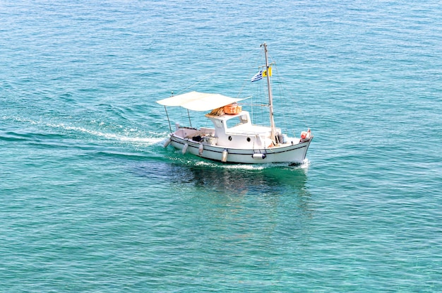 Kleine vissersboot op het kristalheldere strand van Corfu, Griekenland.