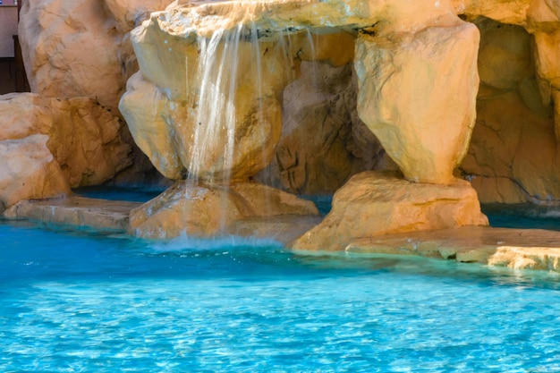 Kleine waterval met turkoois water in het hotelzwembad