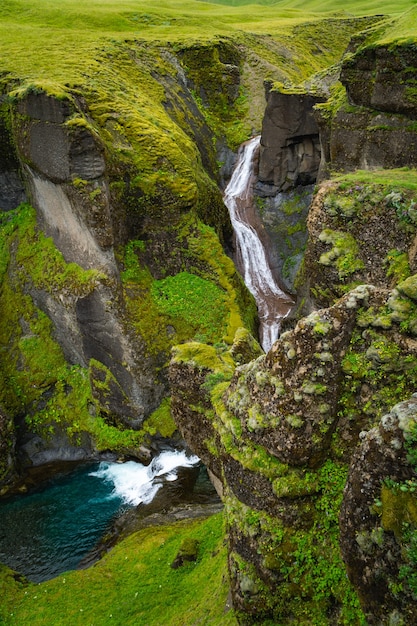 Kleine waterval voedt in een Mossy Canyon in IJsland